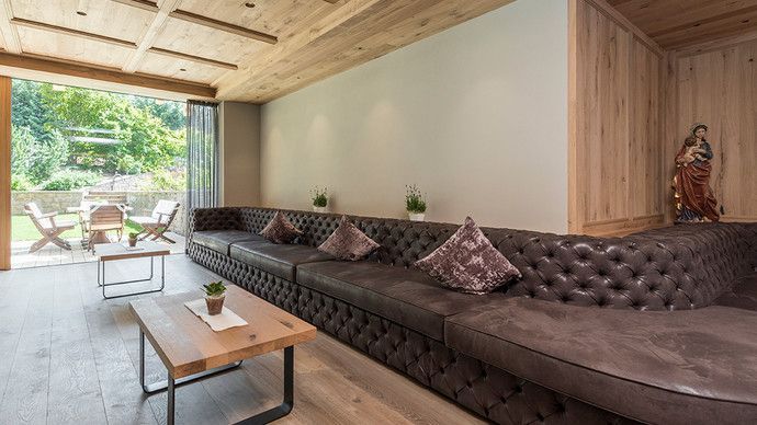 Ein Hotel mit einer langen Couch und  Couchtischen.