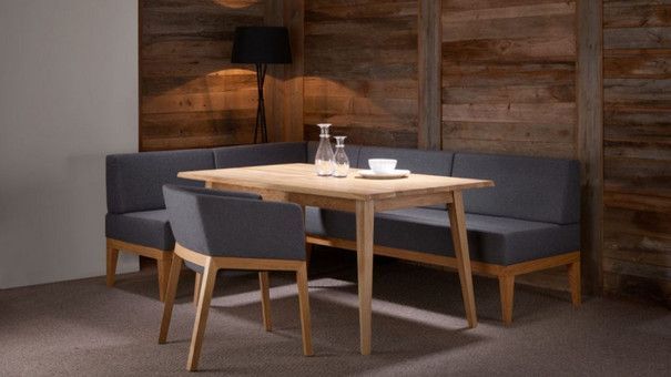 Ein Esszimmer mit einem Tisch und Stühlen vor einer Holzwand.