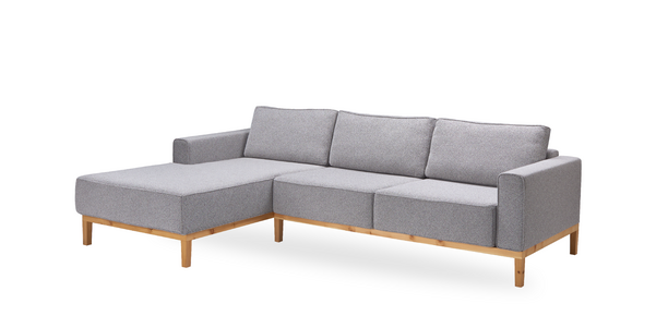 Ein graues Sofa mit Holzbeinen auf weißem Hintergrund.