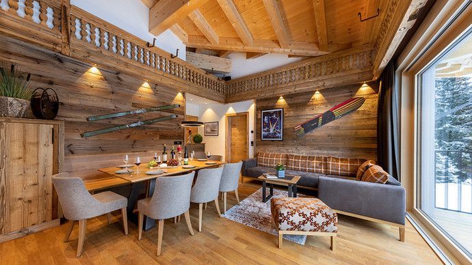 Ein Wohnzimmer mit Esstisch und Stühlen und einem großen Fenster.