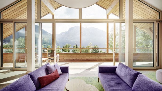 Ein Raum mit einem lila Sofa und einem großen Fenster mit Bergen im Hintergrund.