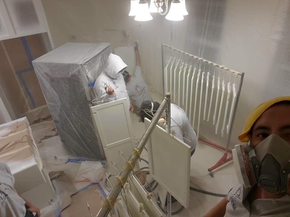 Person in a respirator amid a cluttered room with wrapped furniture and renovation materials