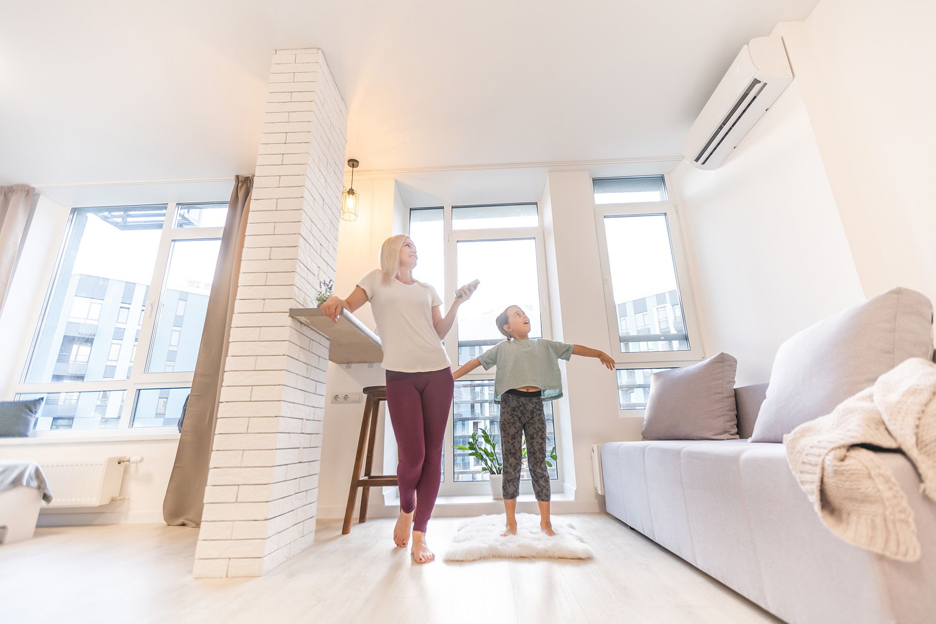 A woman and a child are dancing in a living room.