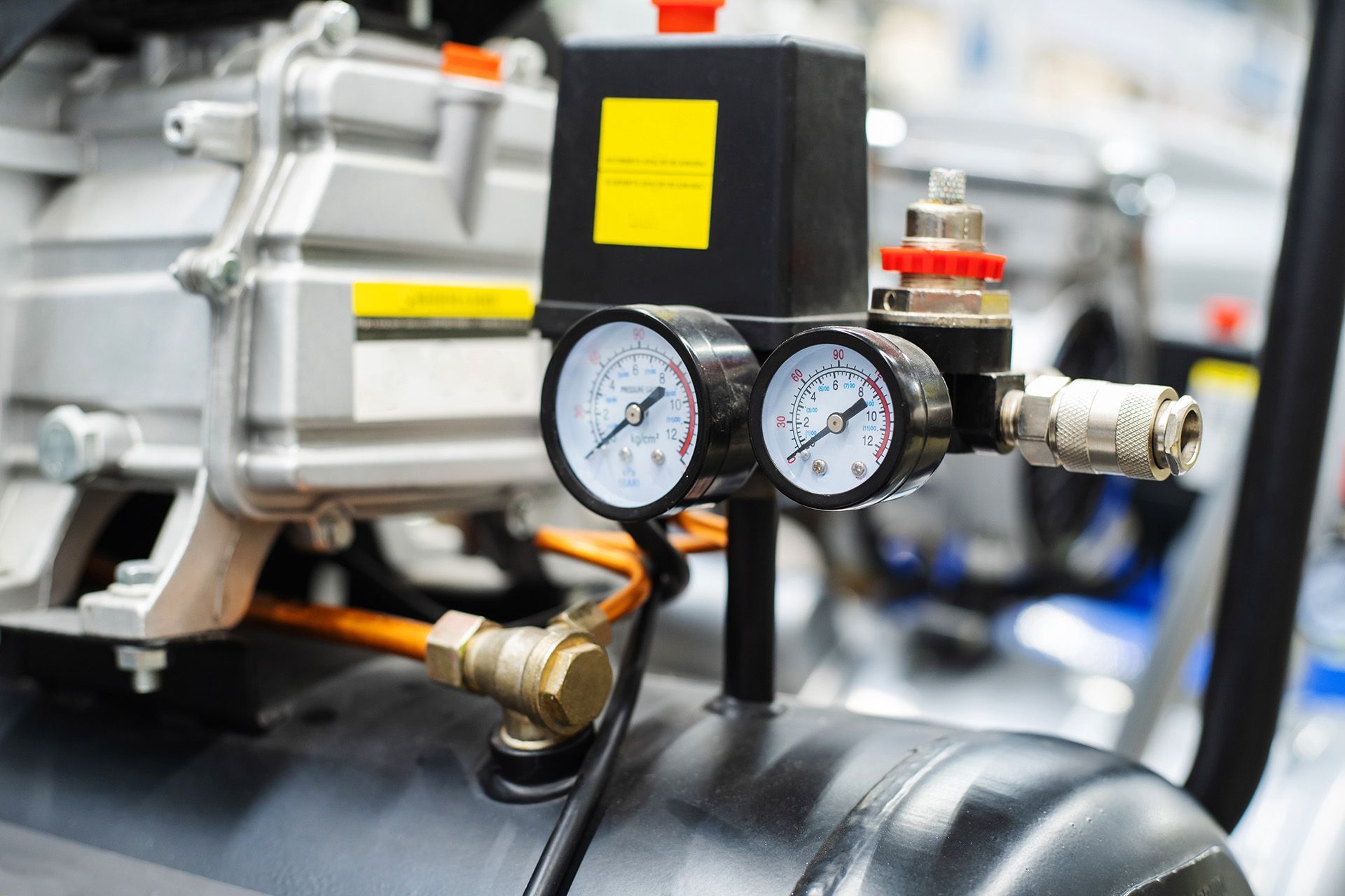 A close up of a air compressor with two gauges attached to it.