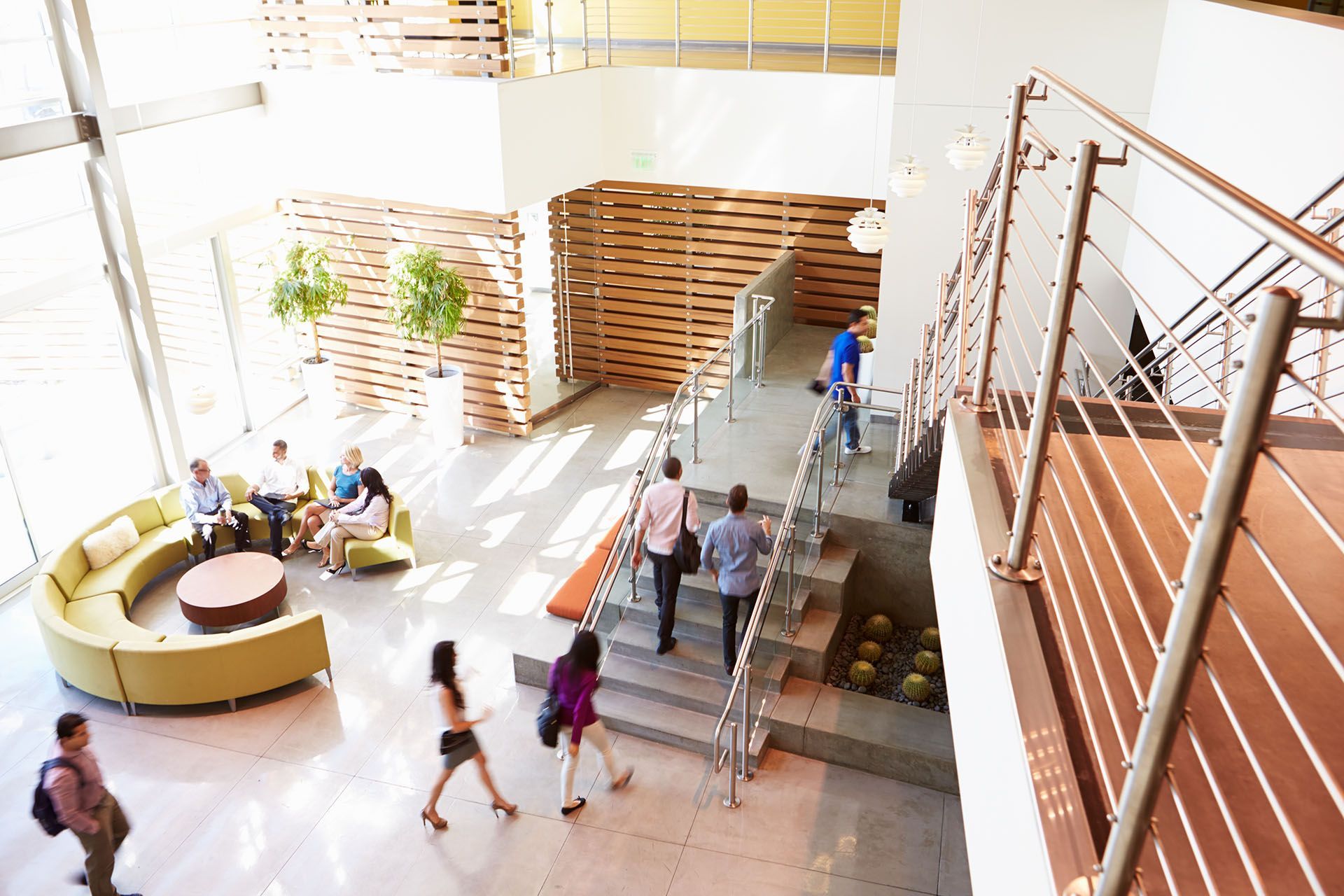 A group of people are walking down stairs in a lobby.