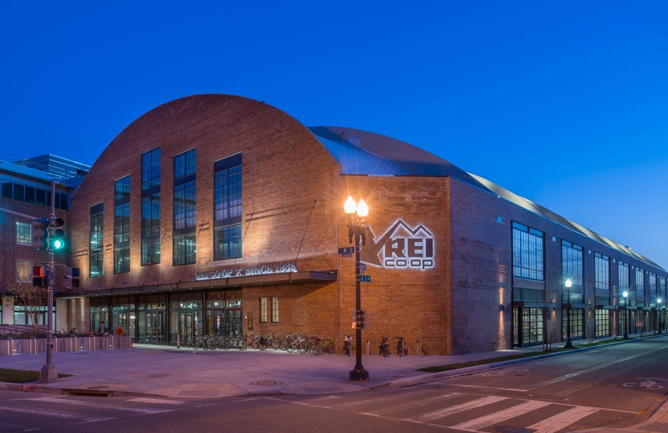 A large brick building with a dome roof is lit up at night.