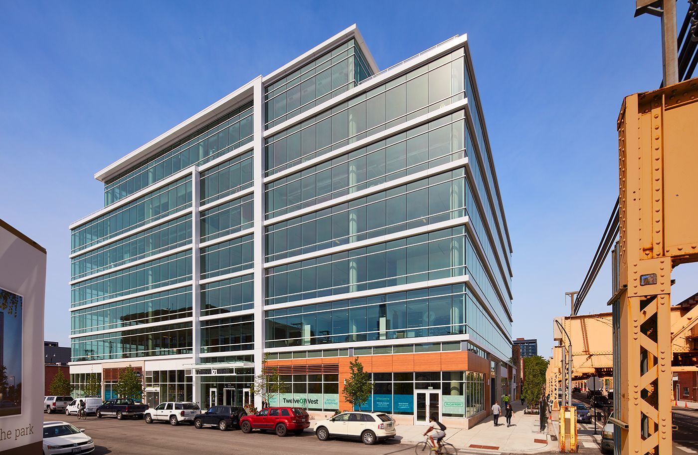 A large building with a lot of windows and cars parked in front of it.