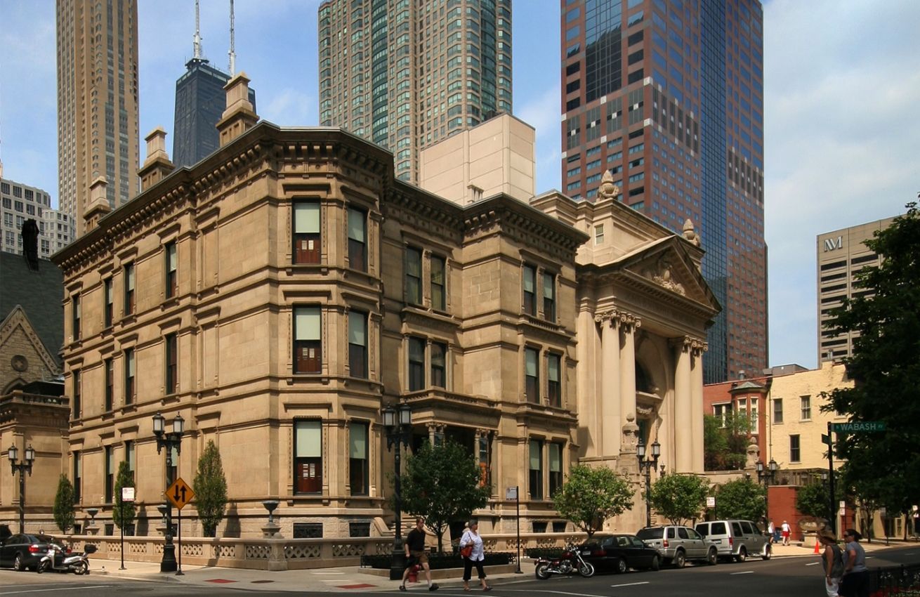 A large building is sitting on the corner of a city street