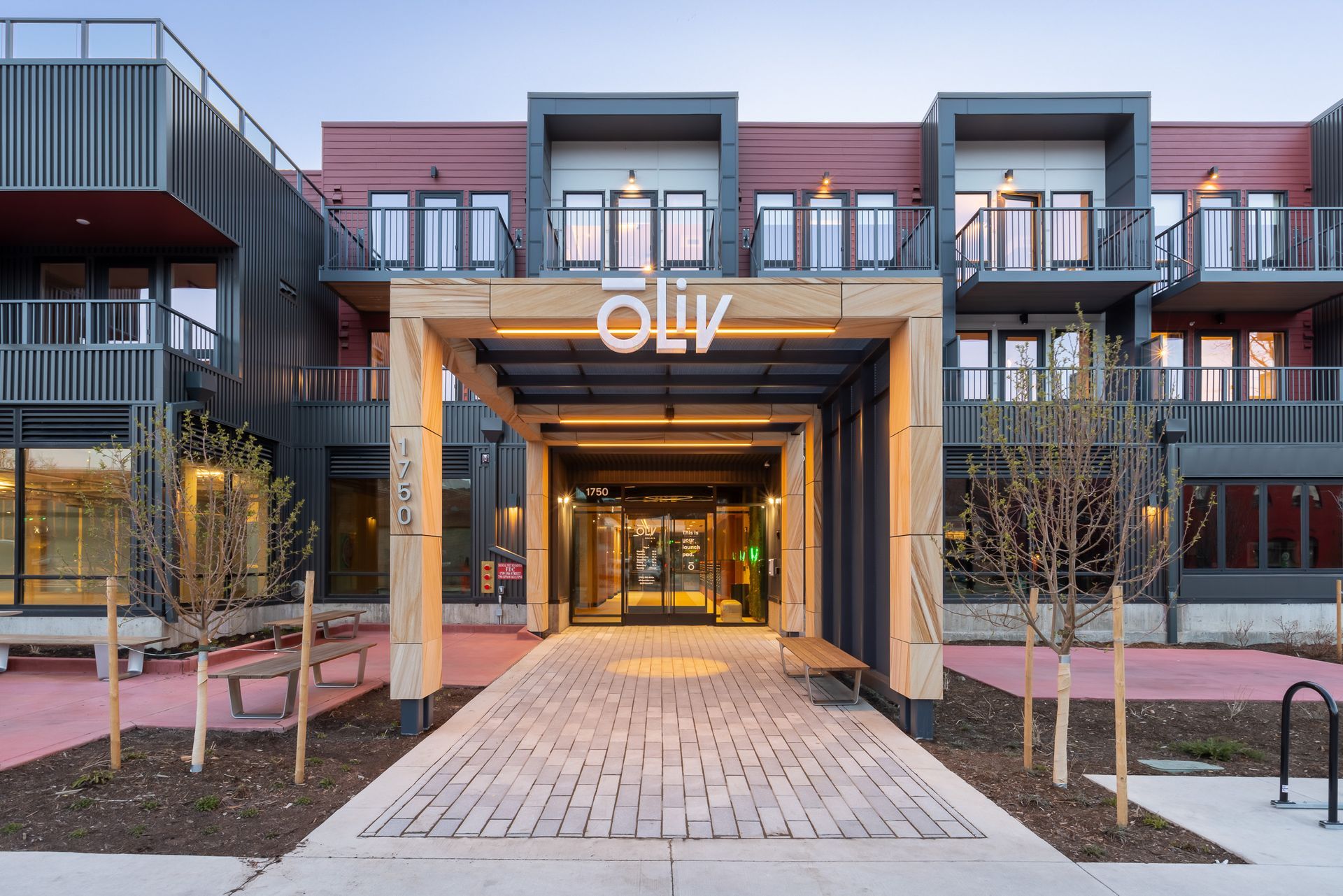 A large apartment building with a brick walkway leading to the entrance.