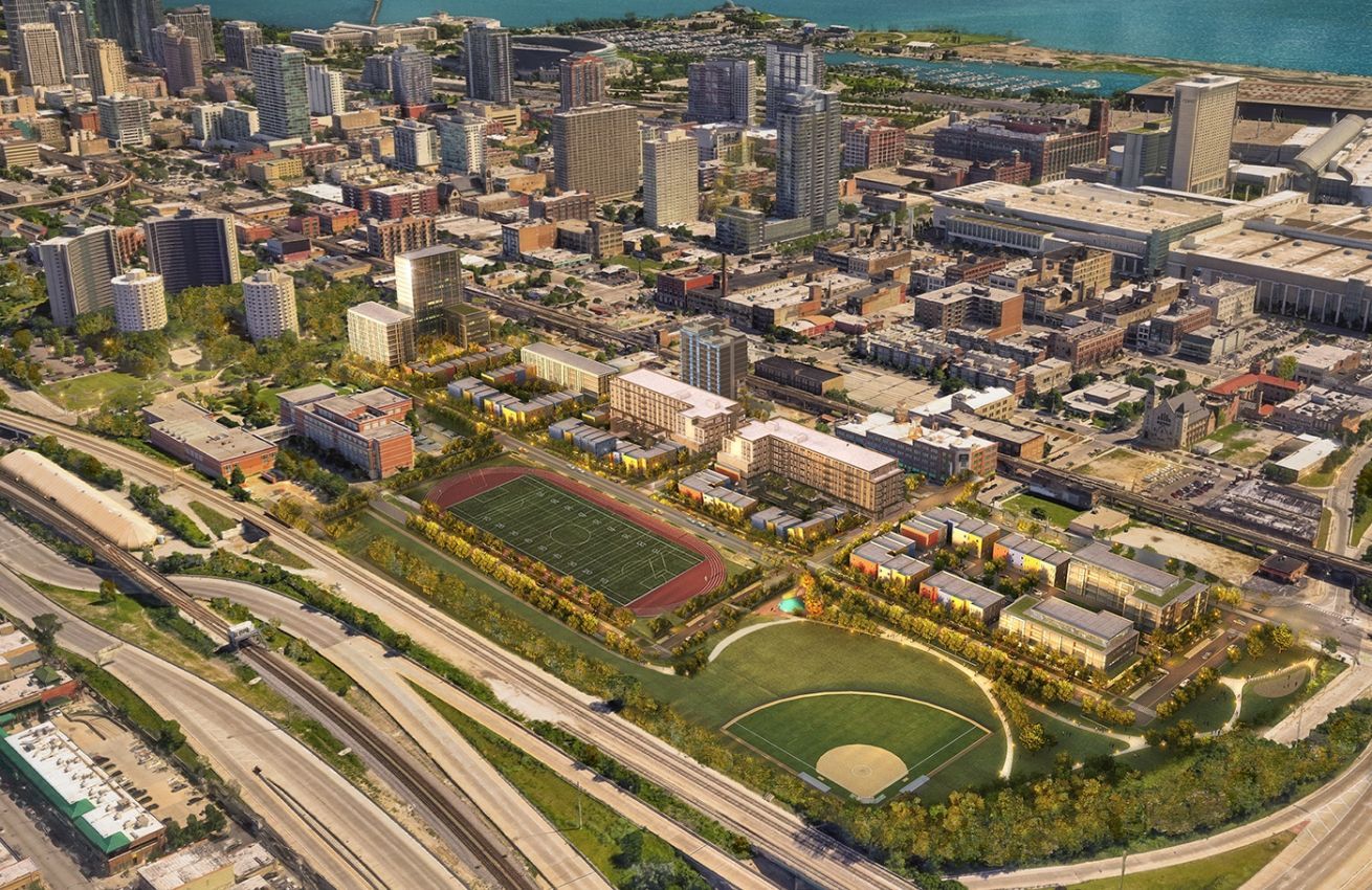 An aerial view of a city with a baseball field in the middle of it.