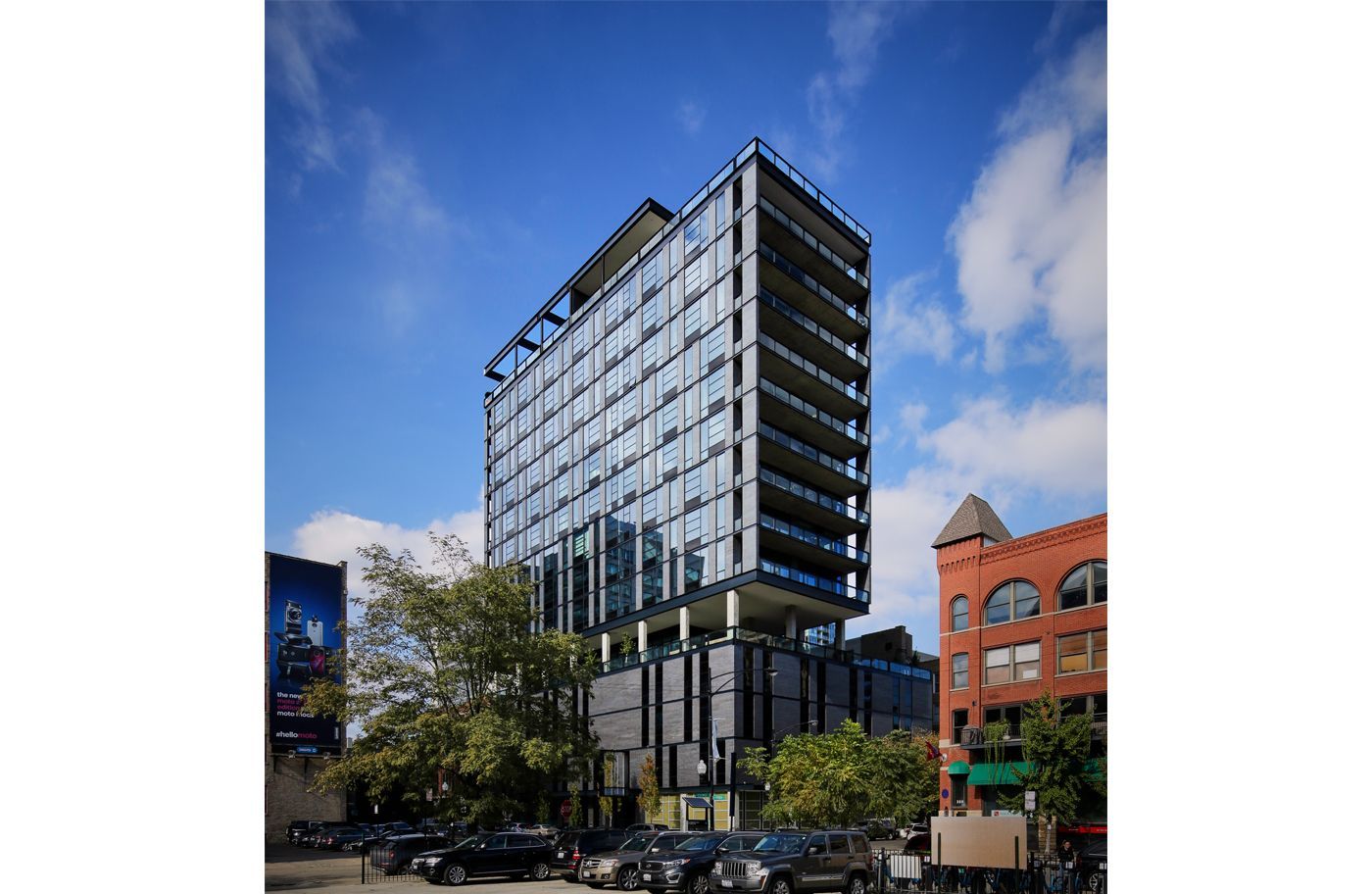 A tall building with a lot of windows is in the middle of a city.