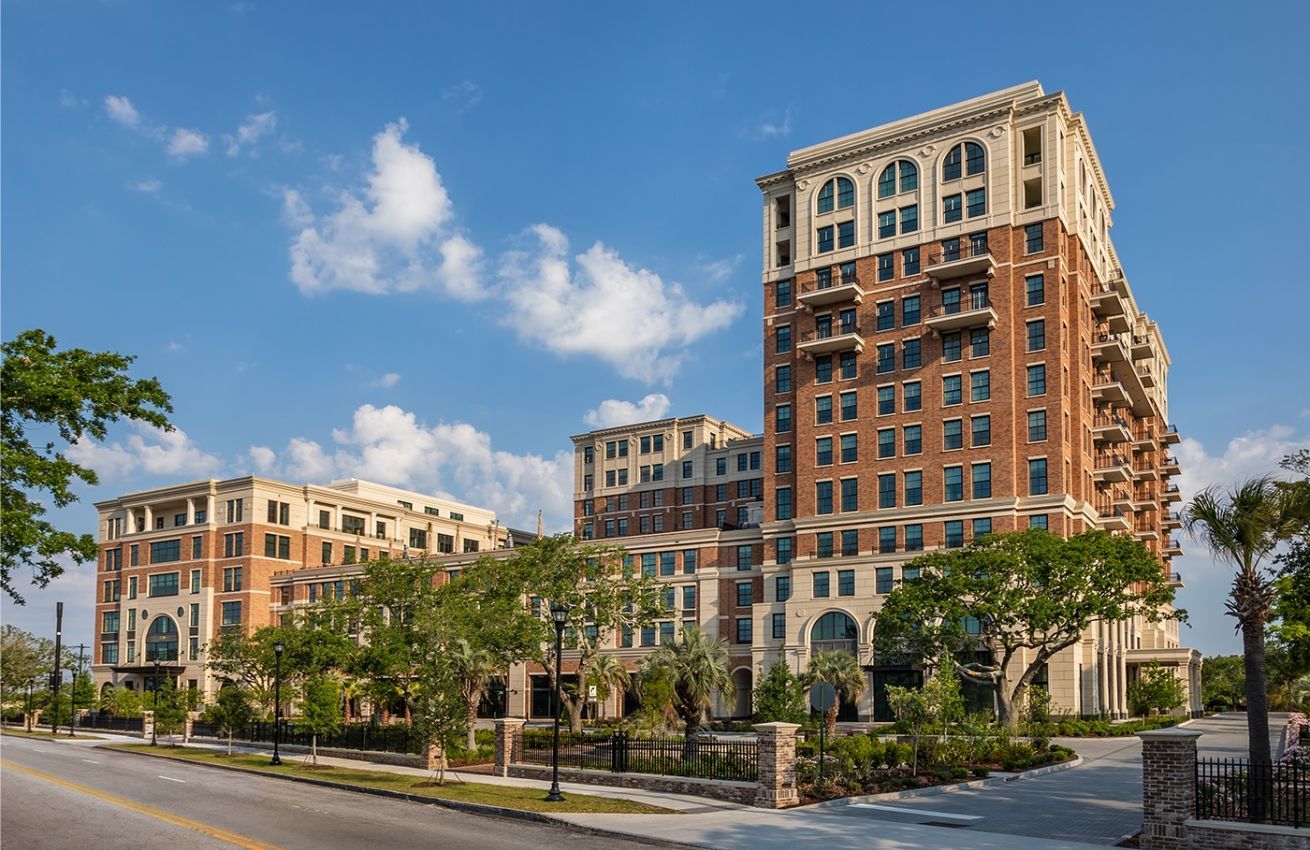 A large brick building with a lot of windows is sitting next to a street.