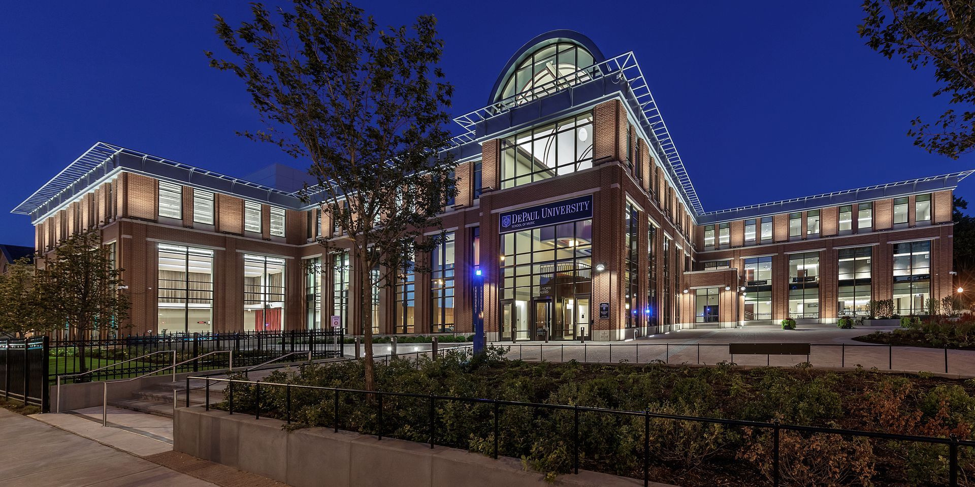 A large building with a lot of windows is lit up at night.