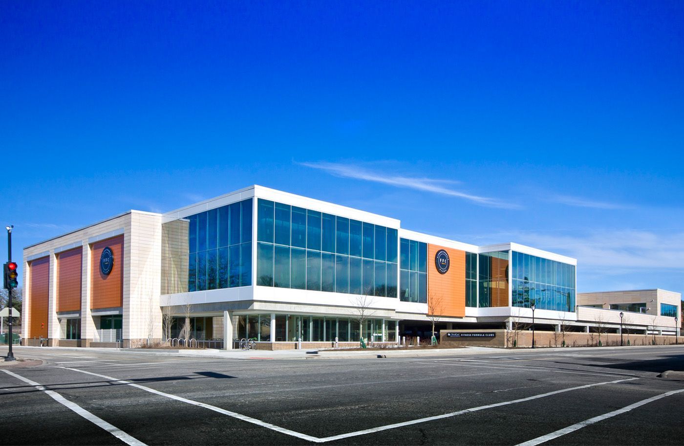 A large building with a lot of windows and a parking lot in front of it