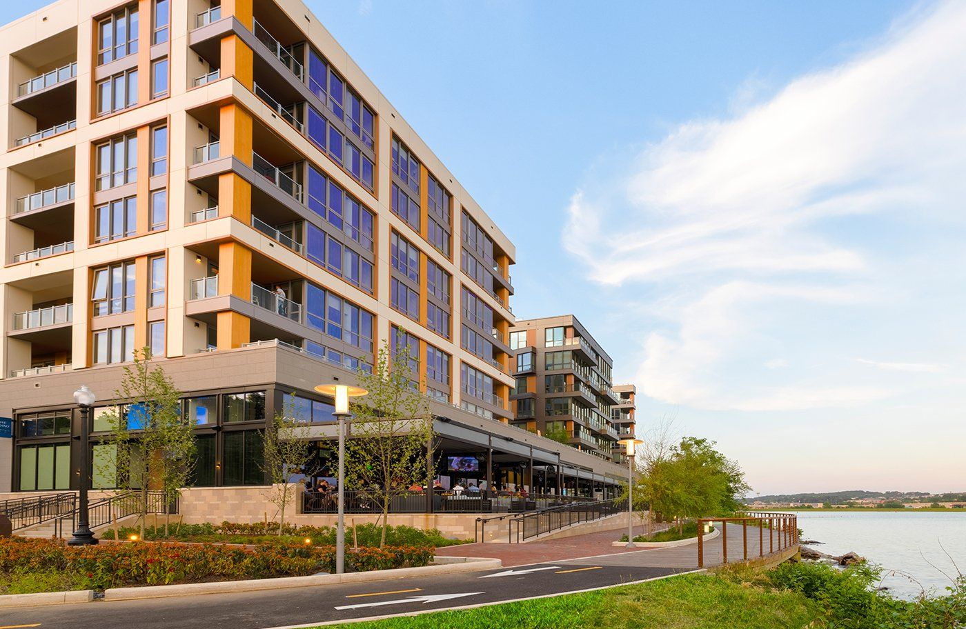 A large building with a lot of windows is next to a body of water.