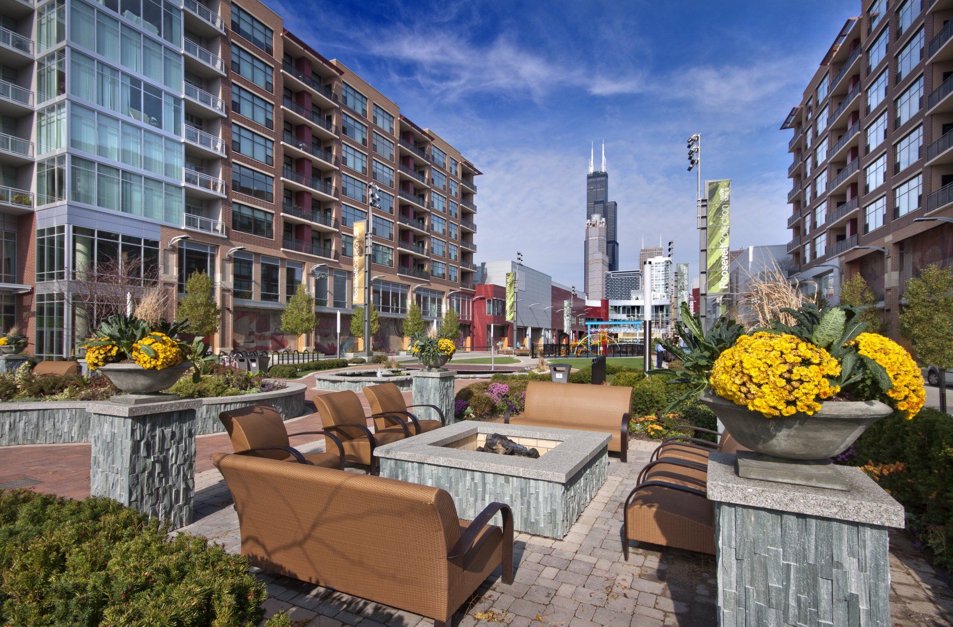 A patio area with a fire pit in the middle of a city