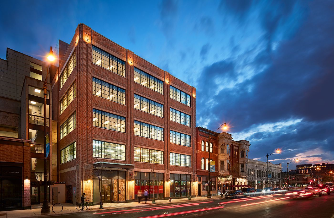A large brick building is sitting on the corner of a city street.