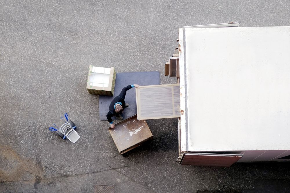 Man Unloading Furniture From A Truck — Removalist In Yamba