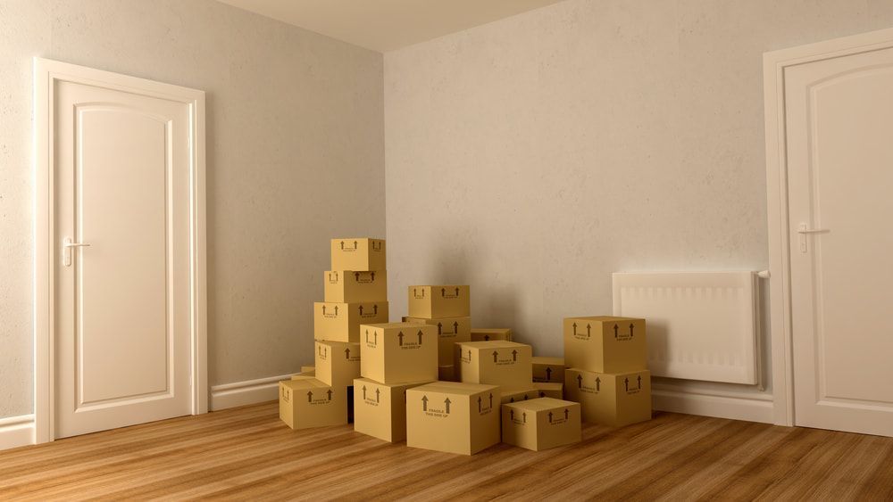 A Room With A Stack Of Cardboard Boxes On The Floor — Removalists In Ballina