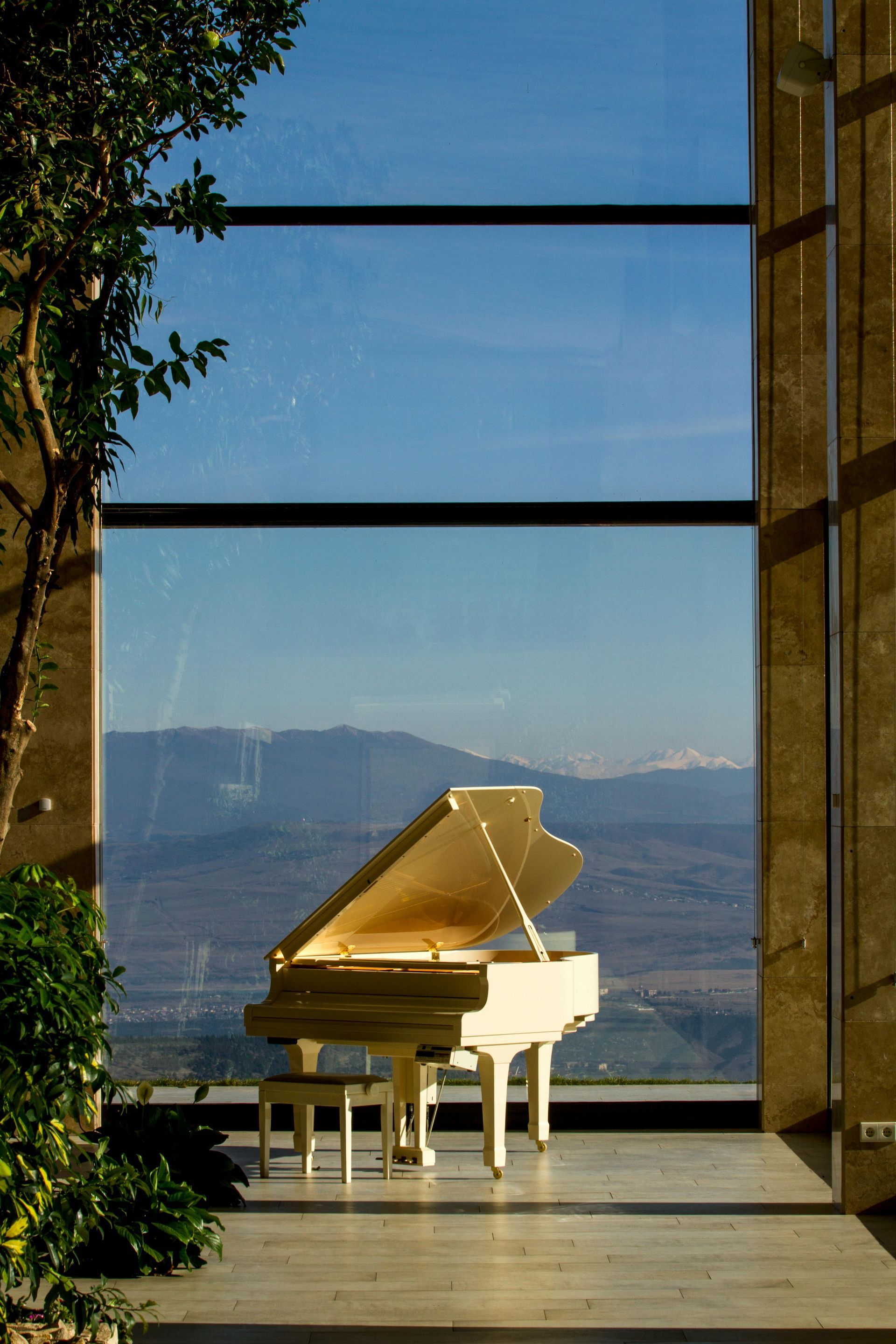 A White Piano In Front Of A Window — Professional Removalists In Alstonville