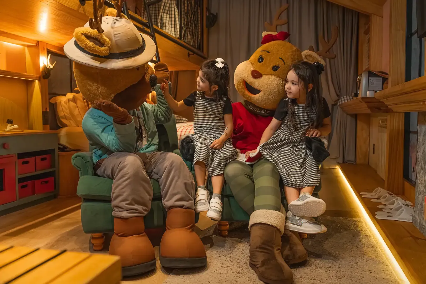 Duas crianças com mascotes em uma sala interna aconchegante.
