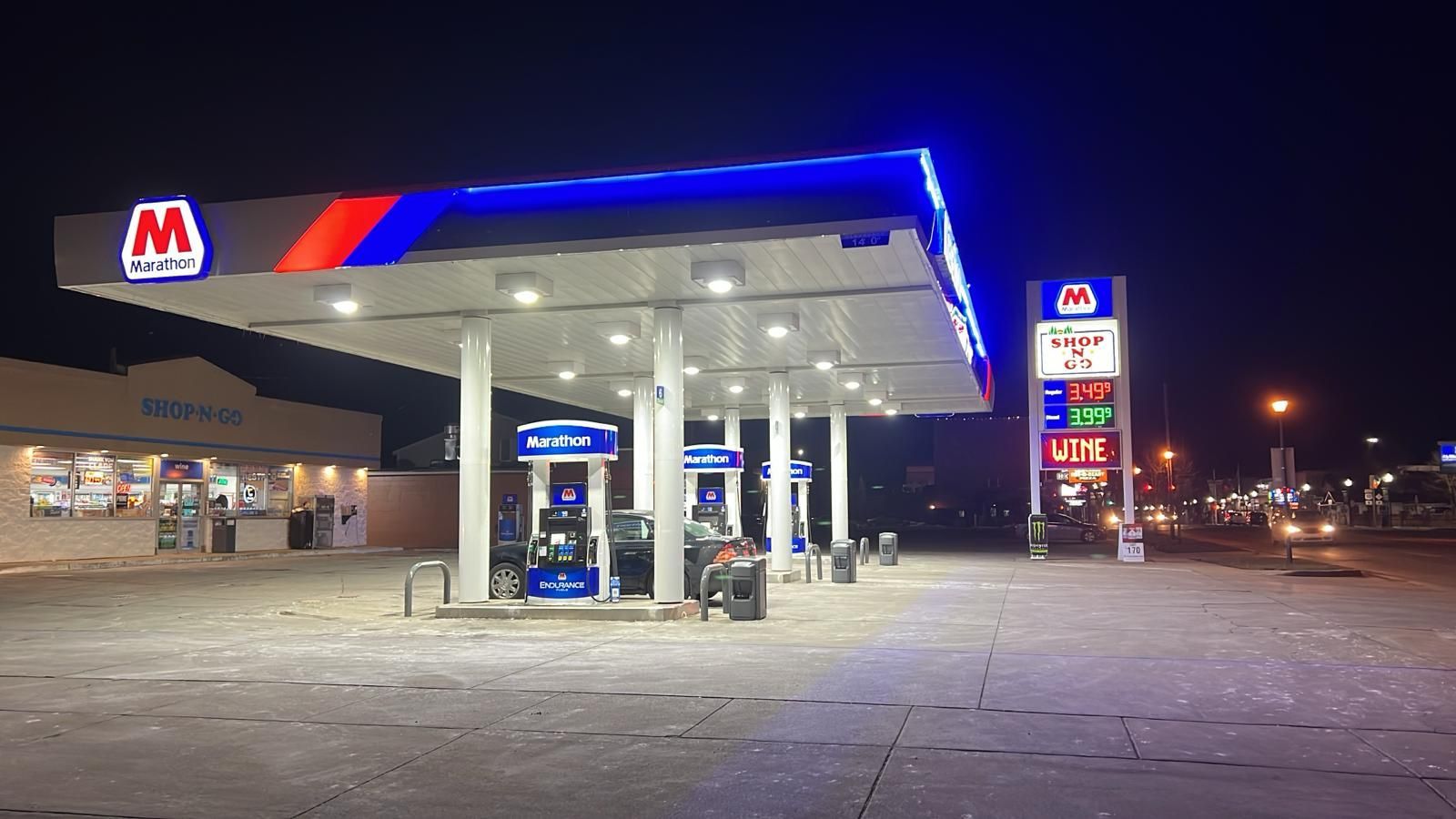 A gas station is lit up at night with a blue roof.