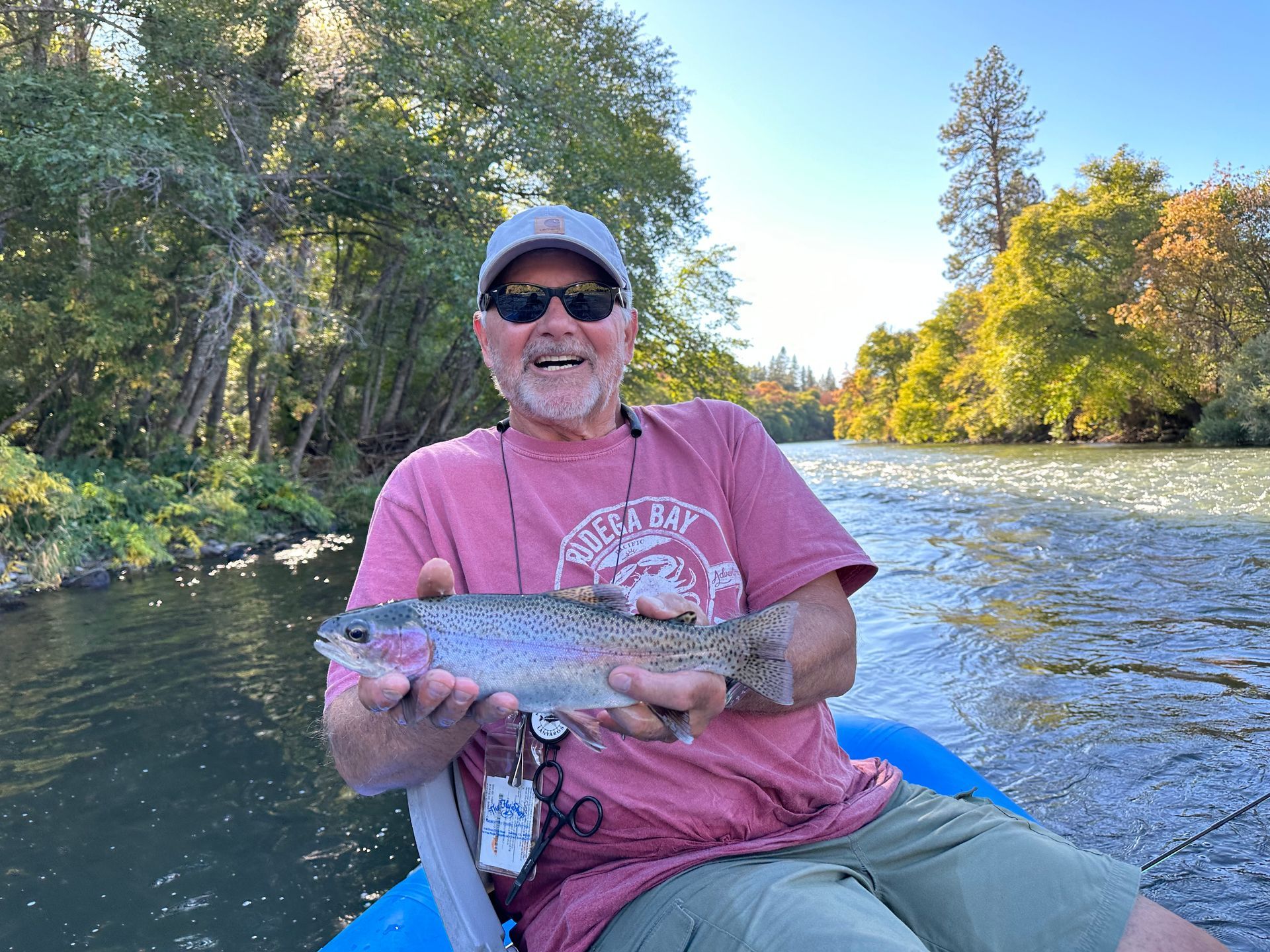 A person is holding a rainbow trout in their hands