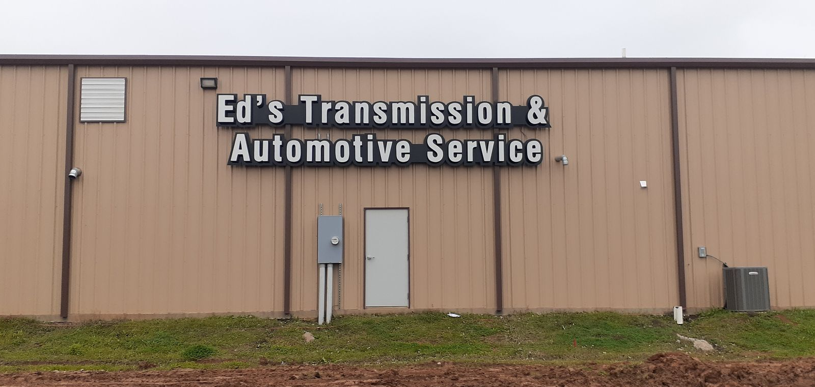 Partial vehicle wrap on a contractor pickup truck with orange and dark branding