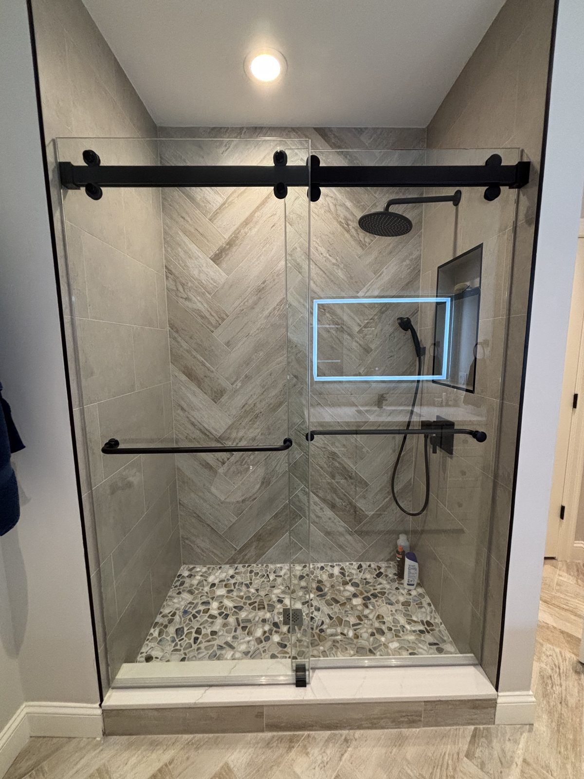 Frameless sliding glass shower door with matte black hardware, Needham, MA