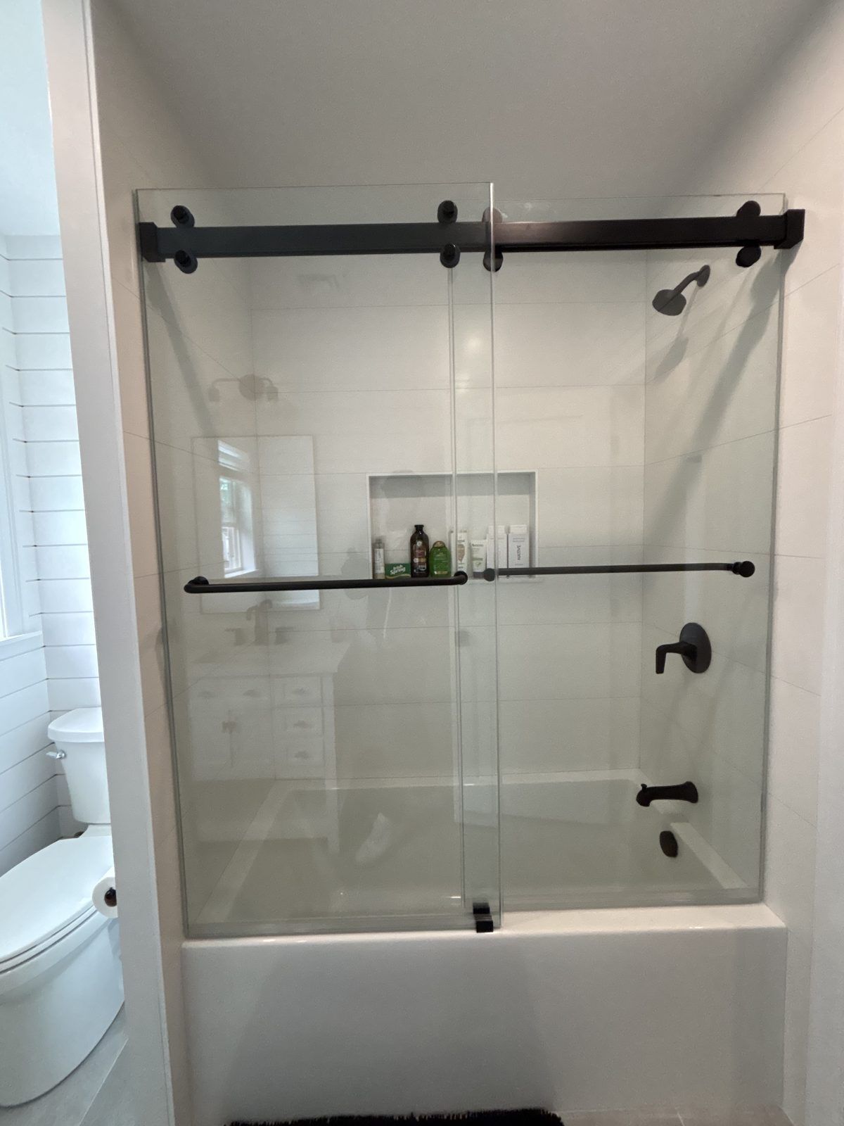 Frameless sliding glass tub doors with matte black hardware, Mashpee, MA