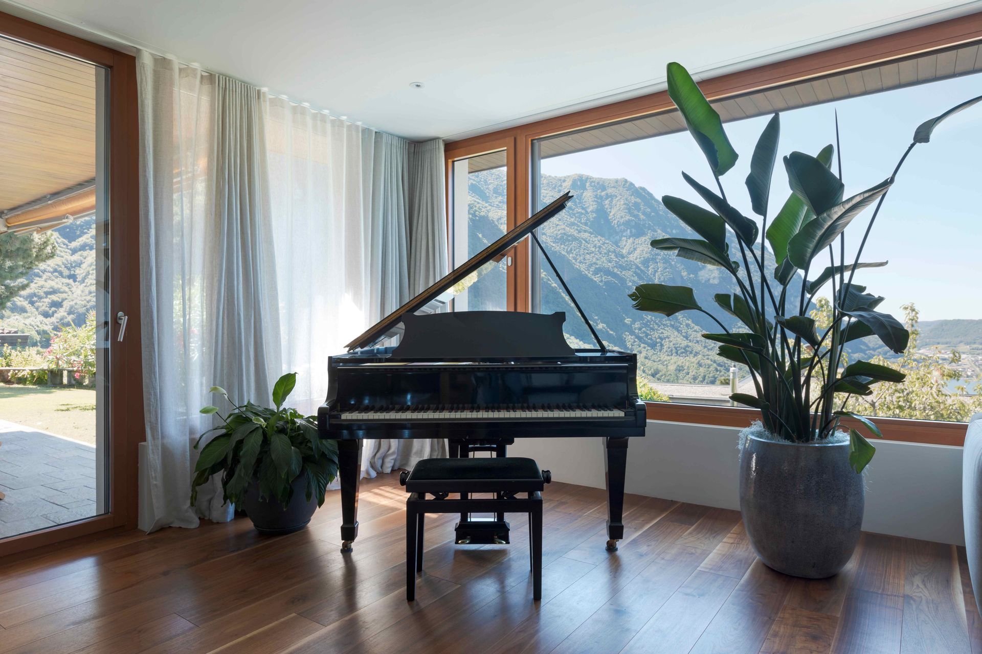 a grand piano is sitting in a living room next to a window