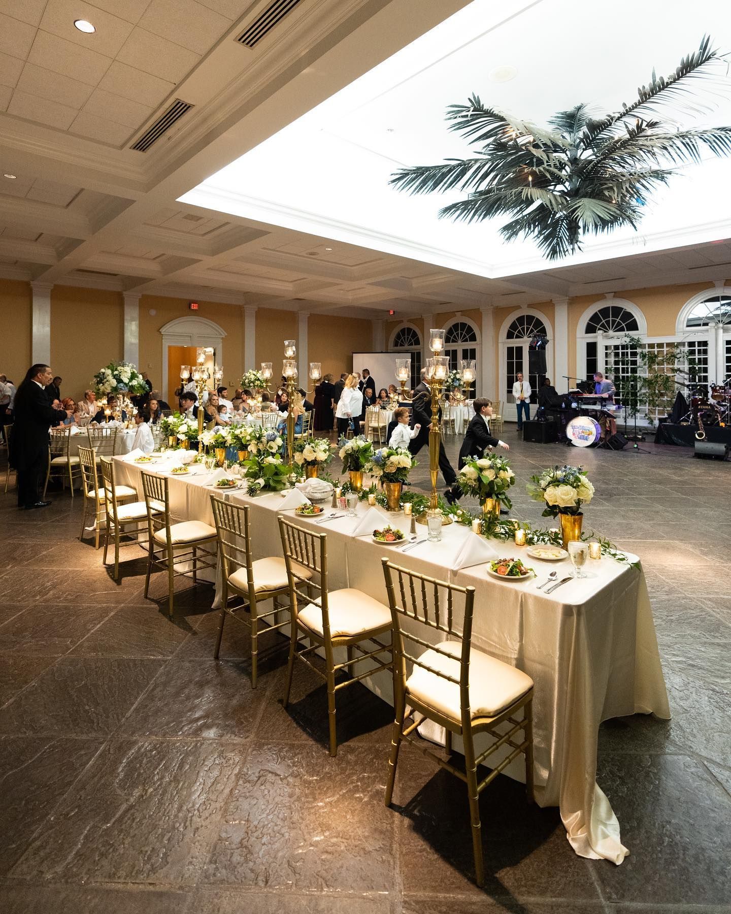 A large room filled with tables and chairs and a chandelier.