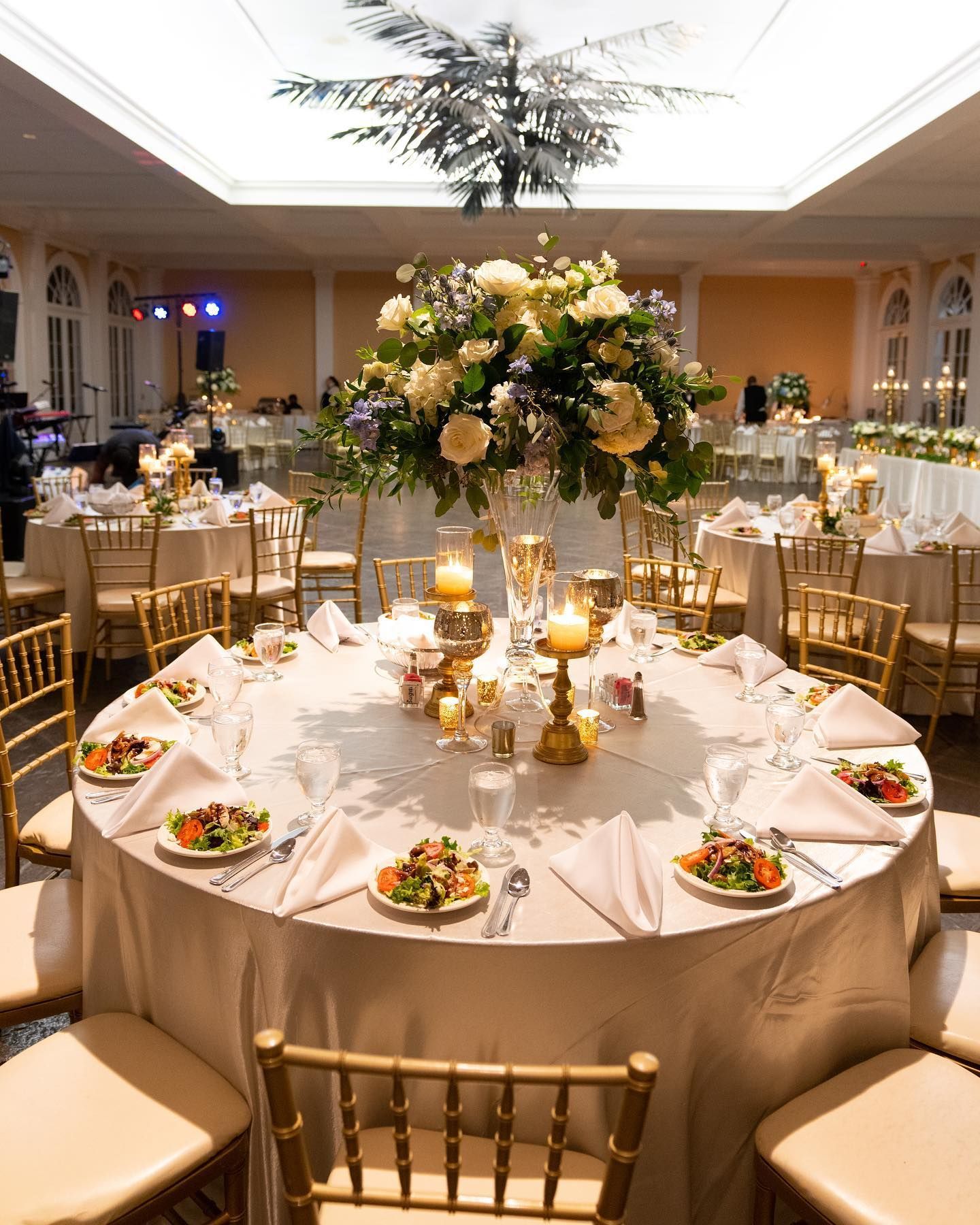 A large room filled with tables and chairs and a chandelier.