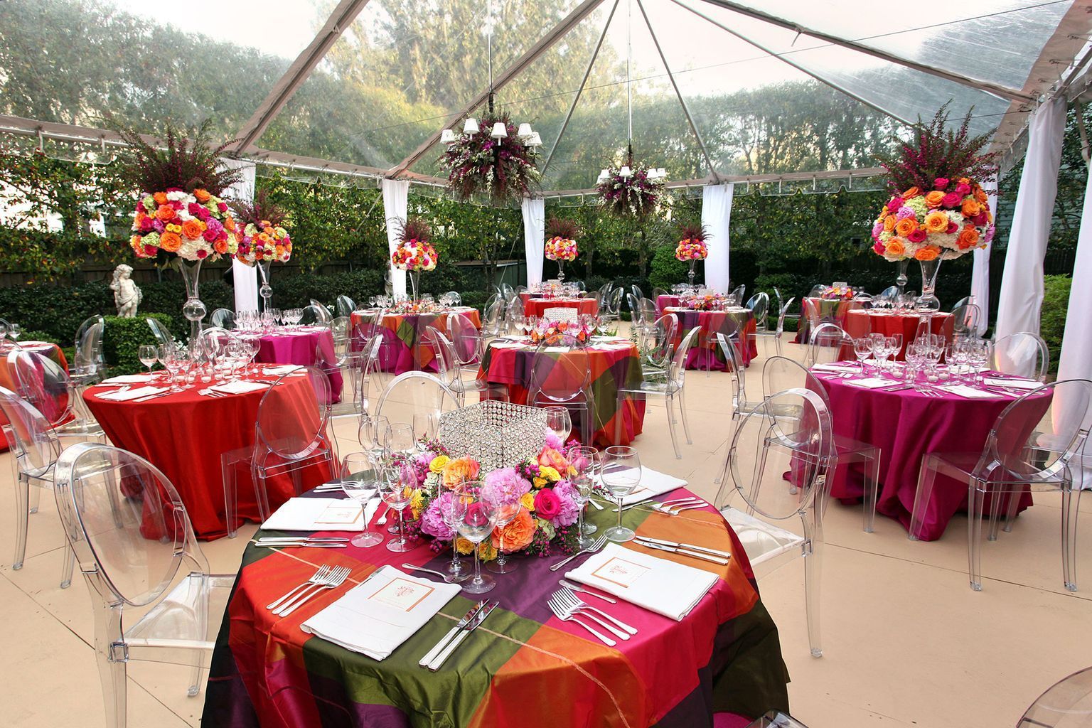 A clear tent with tables and chairs set up for a party