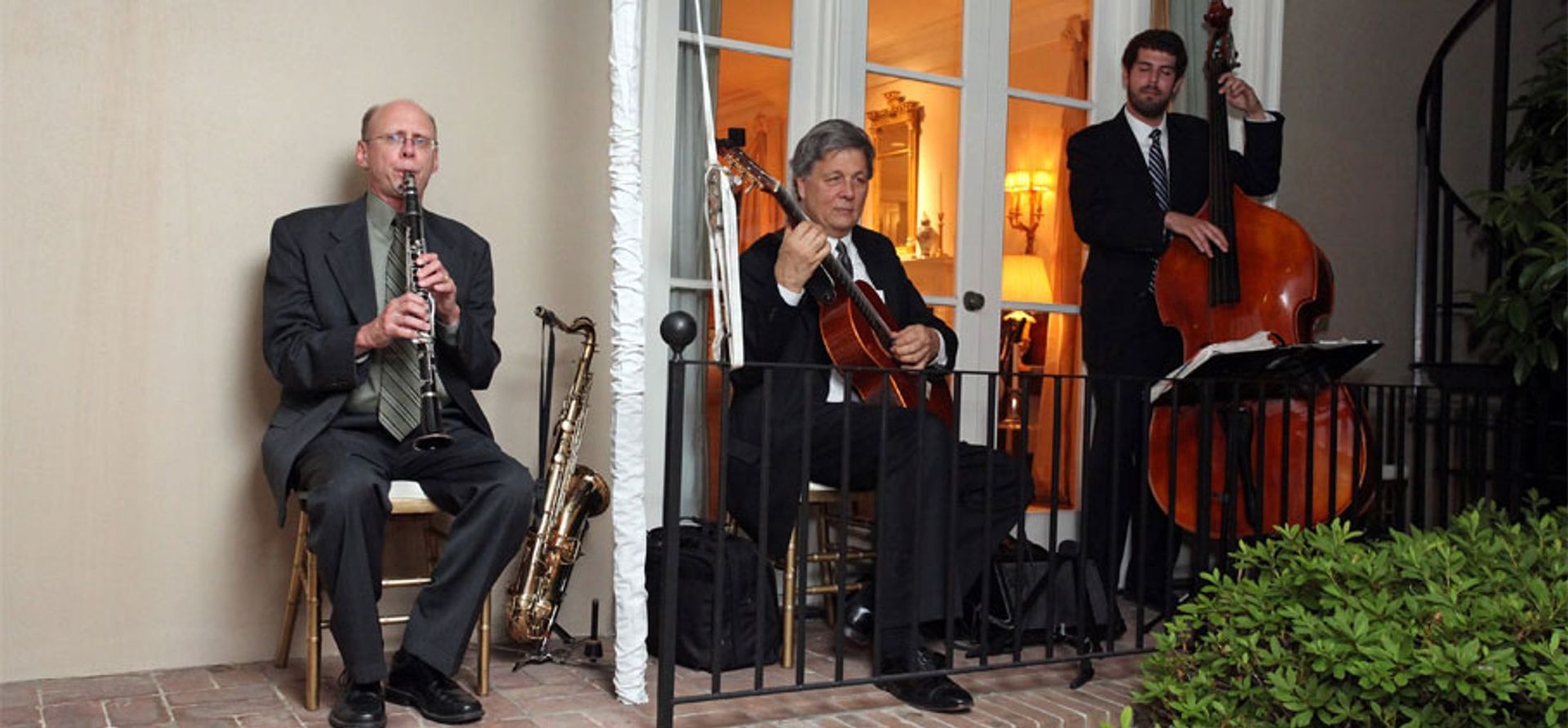 A group of men are playing instruments on a balcony.