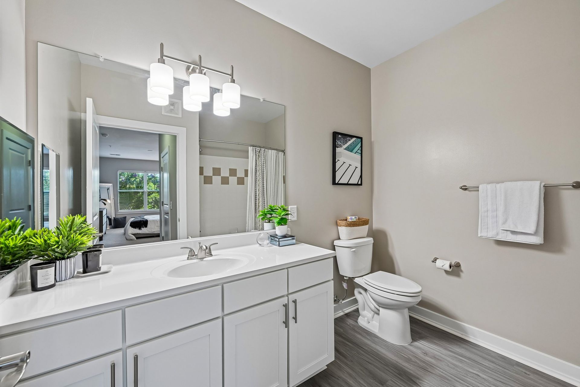 Updated bathroom with white vanity, mirror, and modern fixtures at The View at Mill Run in Owings Mills, MD.