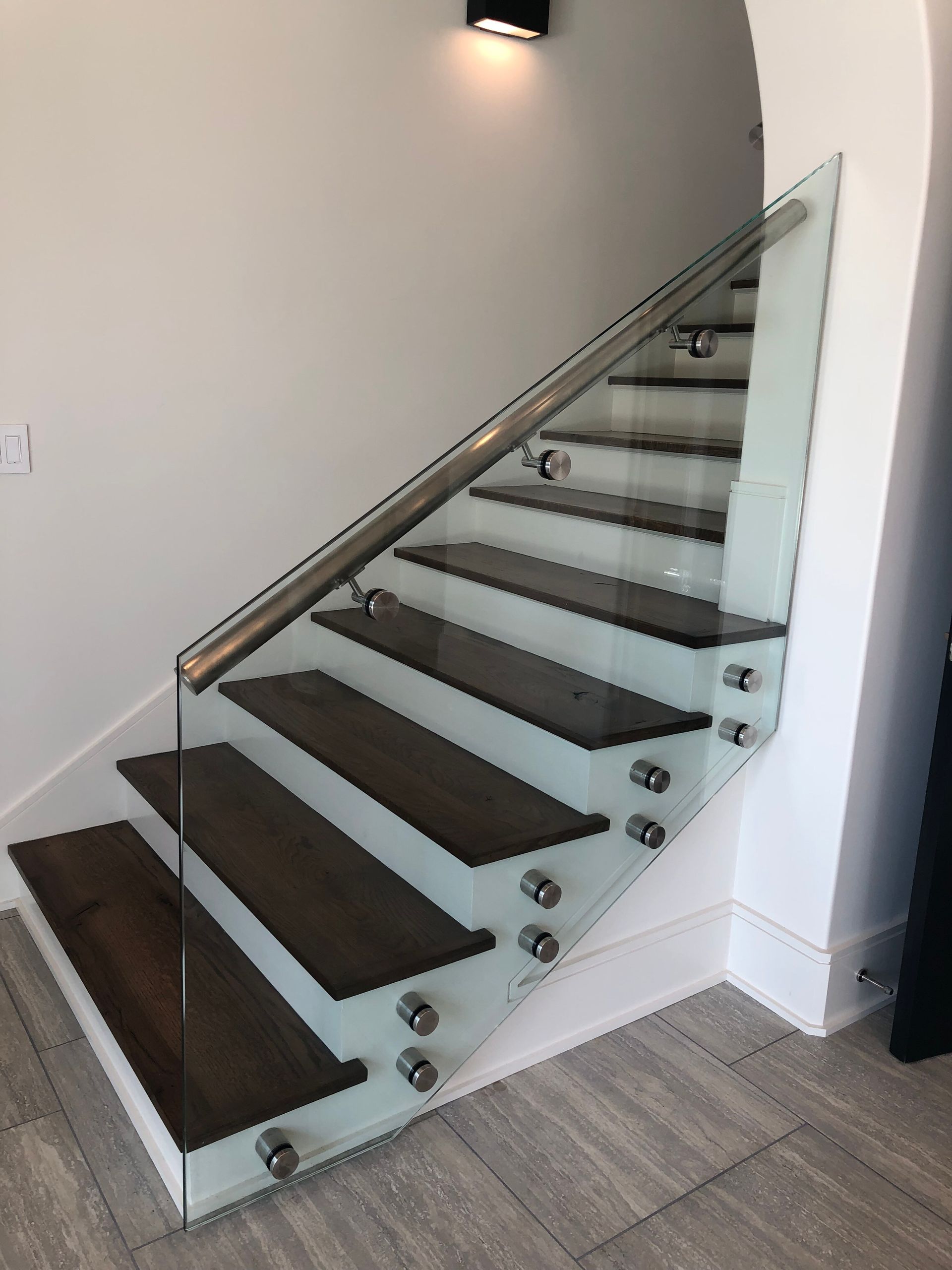 A staircase with a glass railing and wooden steps