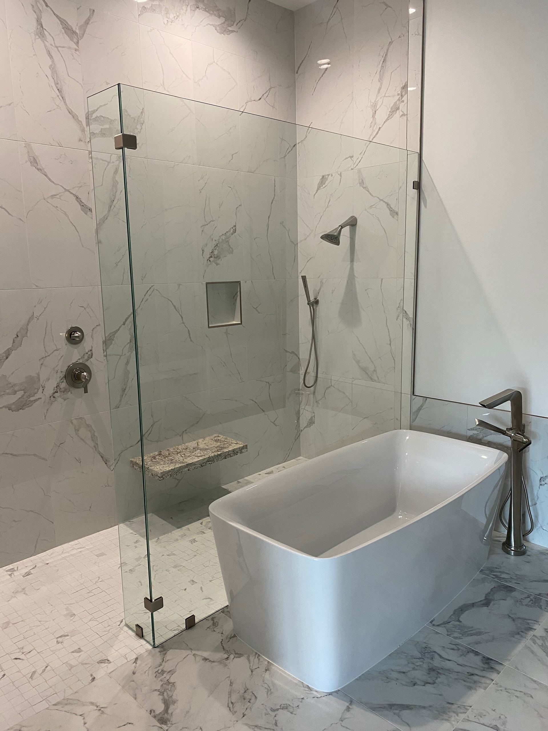A bathroom with a bathtub and a walk in shower.