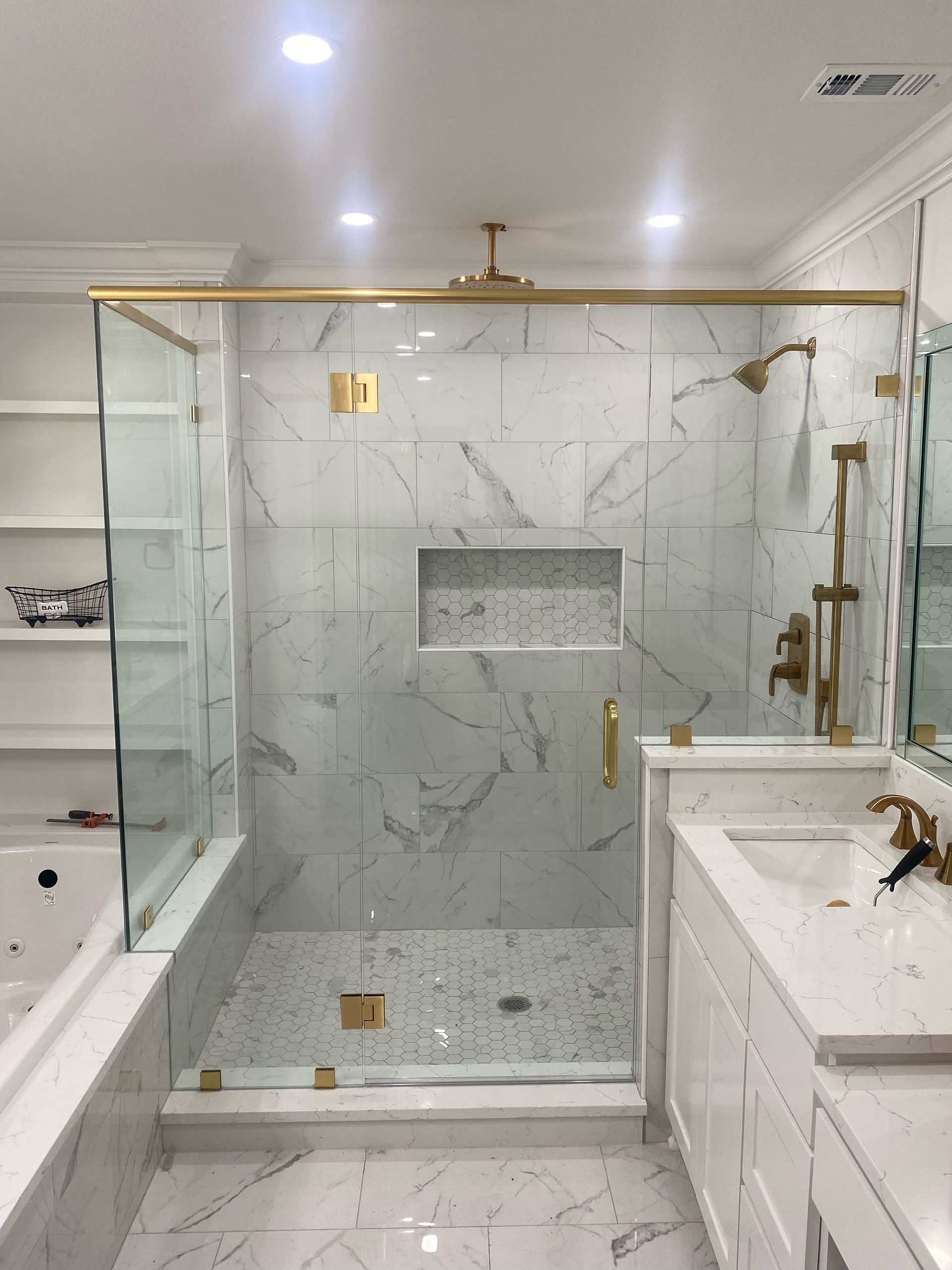 A bathroom with a walk in shower and a sink.