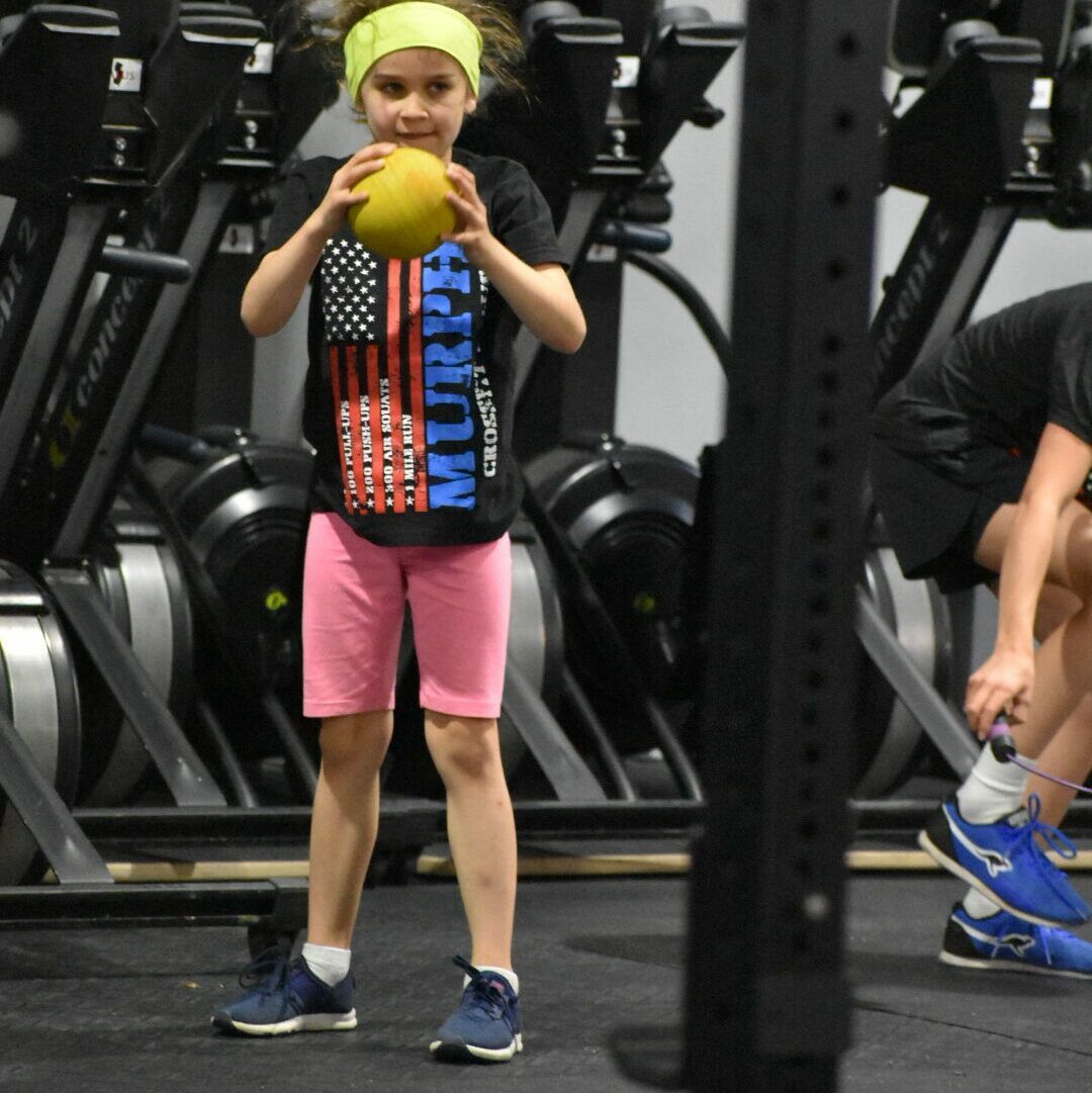A young girl in a gym wearing a shirt that says murray