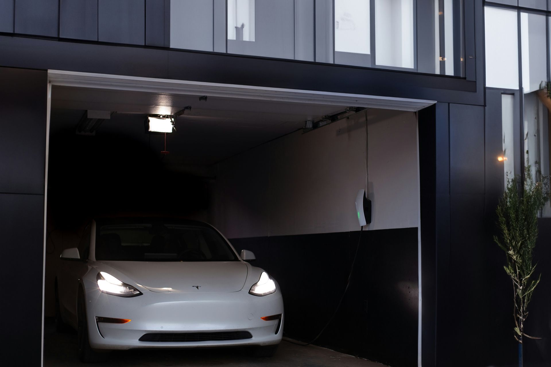 Car exiting newly built garage with built-in charging system