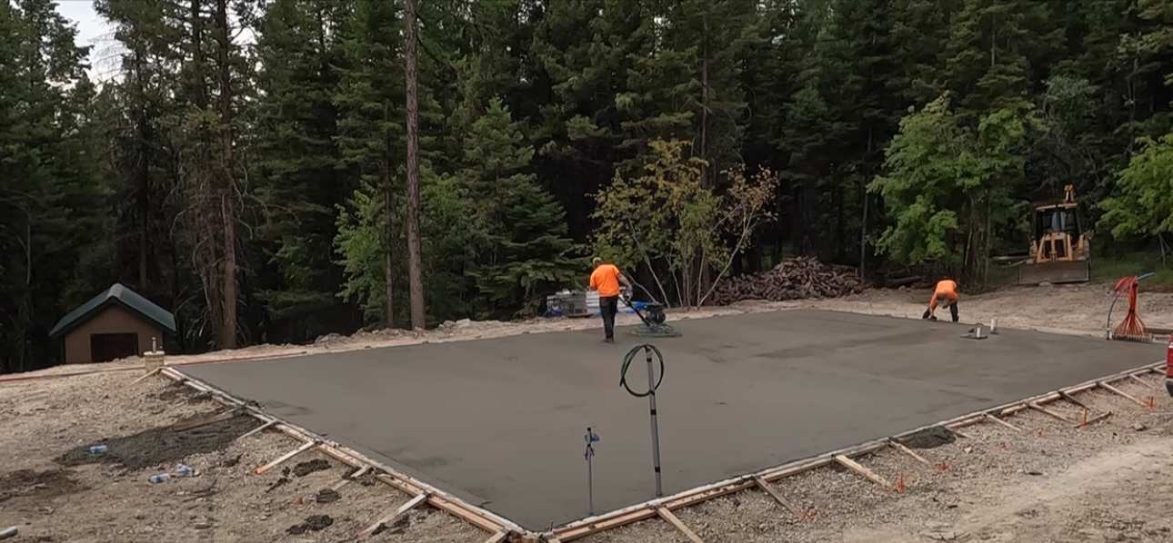Crew member screeding garage foundation