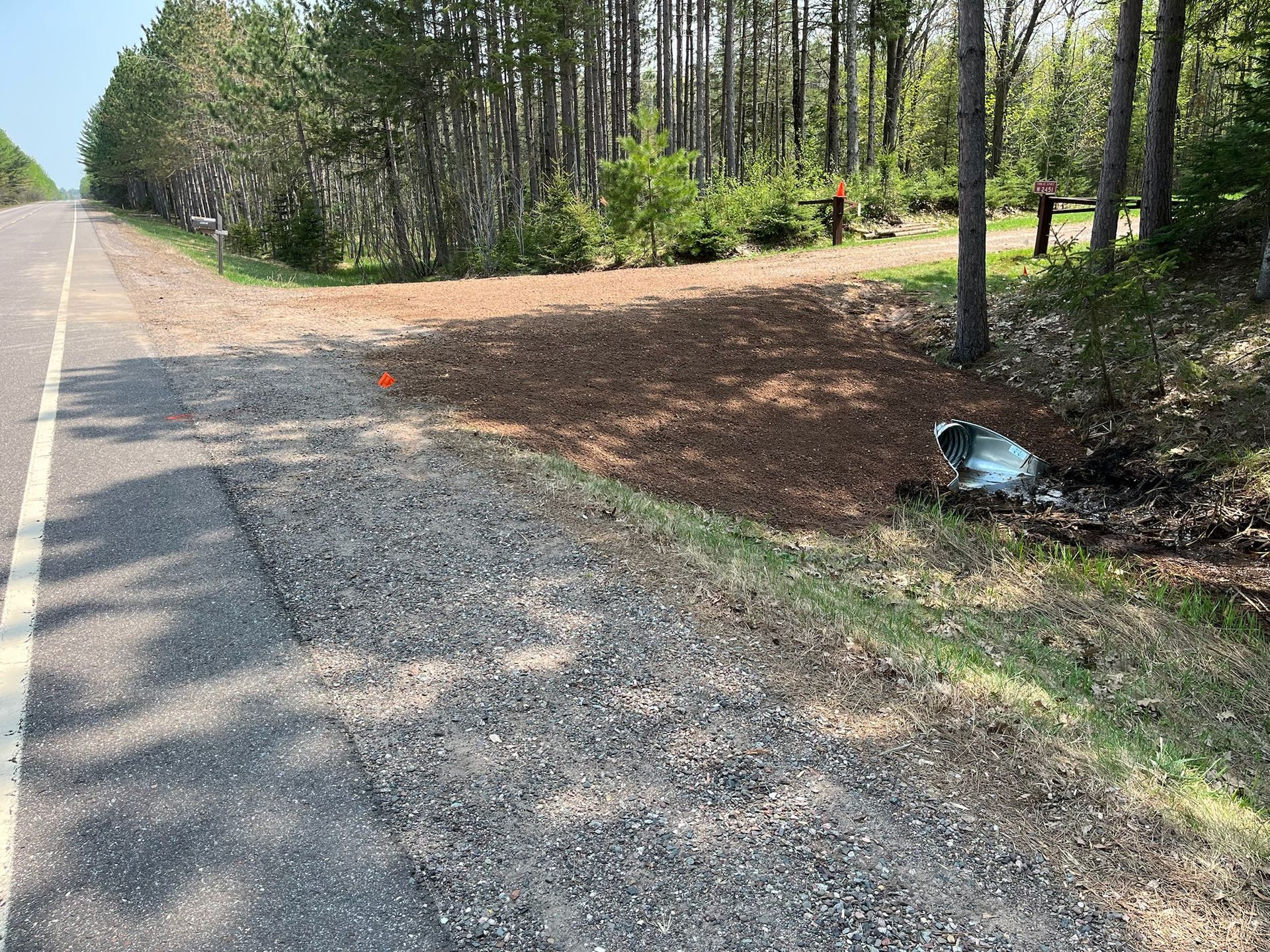 Gravel driveway by woods.