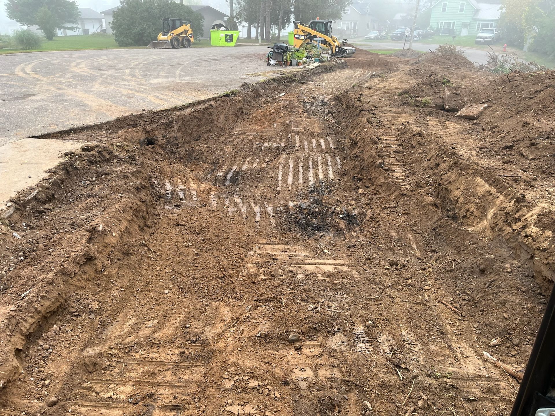 Construction site with dirt piles and heavy machinery.