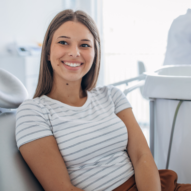 Smiling teen in dental chair after checkup
