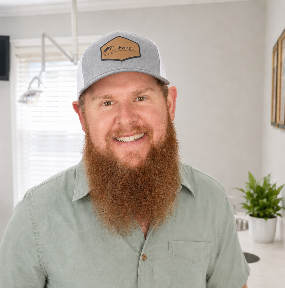 Smiling bearded man in a gray cap and green shirt standing in a bright room