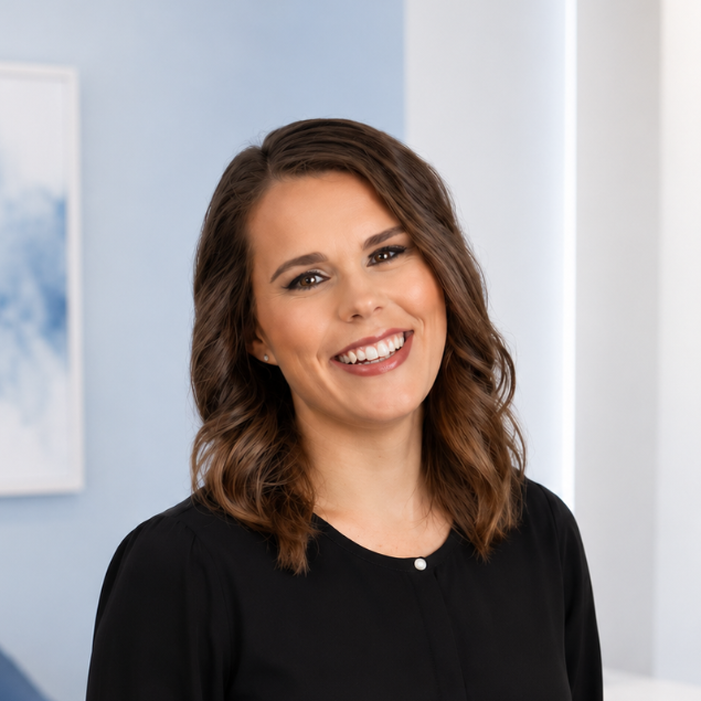 Smiling woman in a black top standing in a bright indoor office setting