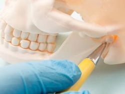 Smiling child in a dental chair giving two thumbs up, with a blue bib and white clinic background