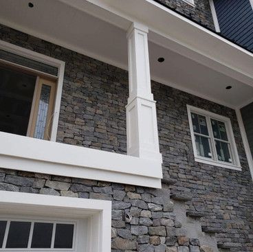 a house with a stone facade and white trim