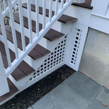 the stairs are made of wood and have a white railing .